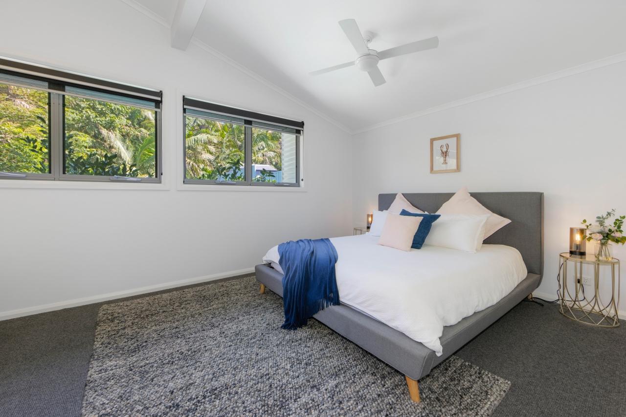 Main bedroom with king bed, ensuite, and walk in robe. has split system aircon and ceiling fan. Middle level. Laze at Lighthouse