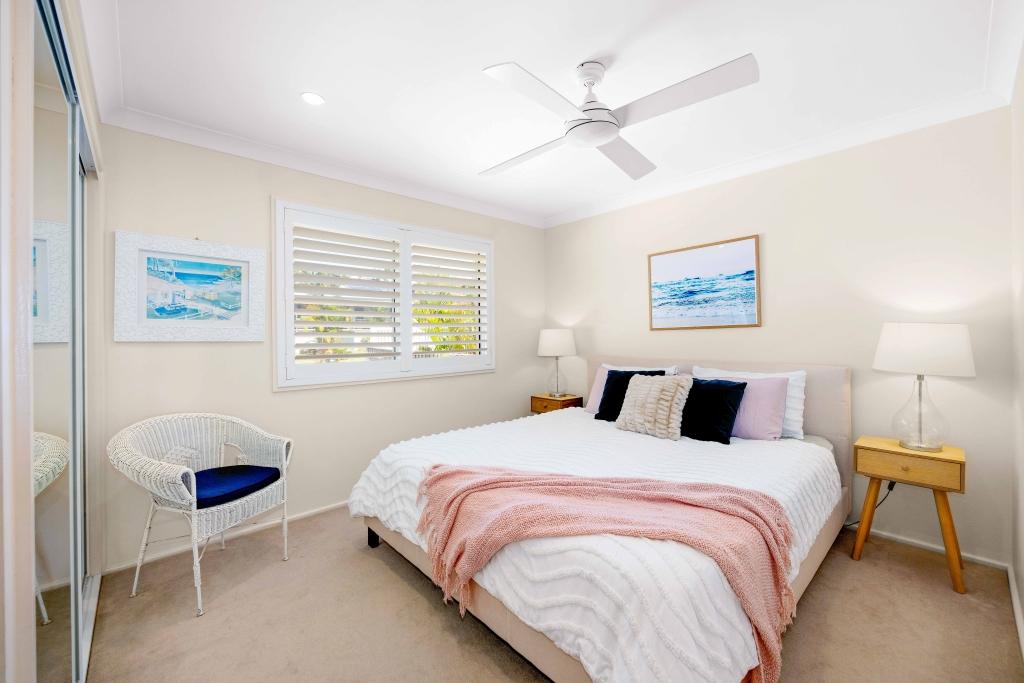 Upstairs bedroom with king sized bed and ceiling fan Allure by the Sea