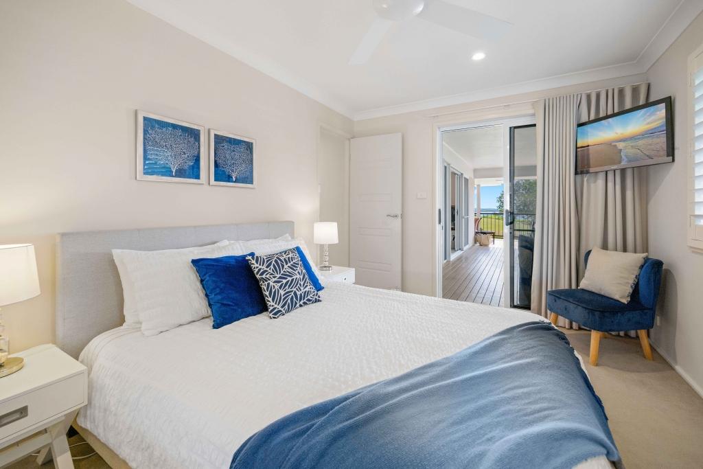 Upstairs bedroom with queen sized bed, ceiling fan and TV Allure by the Sea